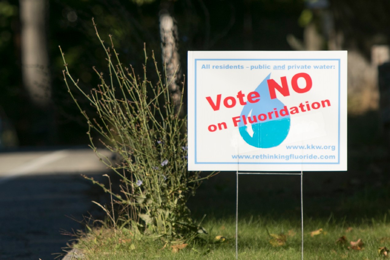 Un cartel con un texto que dice: Vote NO a la fluoración.