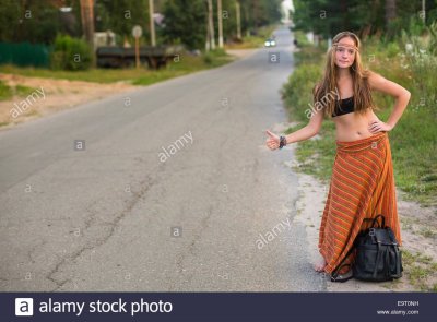 joven-chica-haciendo-autoestop-en-carretera-rural-estilo-hippie-e9t0nh.jpg