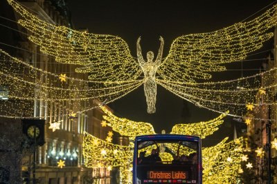 Lights in the shape of angels hang over a London street.