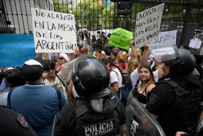 Agentes antidisturbios controlan a un grupo de personas que protesta en Buenos Aires.
