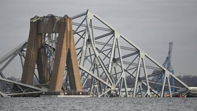 The steel frame of the Francis Scott Key Bridge lies in the water after it collapsed in Baltimore, Maryland, on March 26, 2024. The bridge collapsed early March 26 after being struck by the Singapore-flagged Dali container ship, sending multiple vehicles and people plunging into the frigid harbor below. There was no immediate confirmation of the cause of the disaster, but Baltimore's Police Commissioner Richard Worley said there was no indication of terrorism. (Photo by ROBERTO SCHMIDT / AFP) (Photo by RO