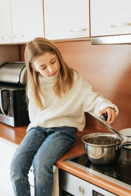 niña de 9 años con cabello largo modelo colegiala en casa estilo de vida en una cocina beige