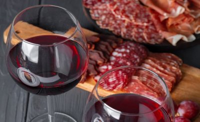 una mesa con vino tinto y plato de carne