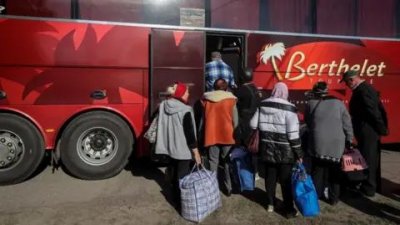 Personas subiendo a un autobús para sacarlos de Vovchansk