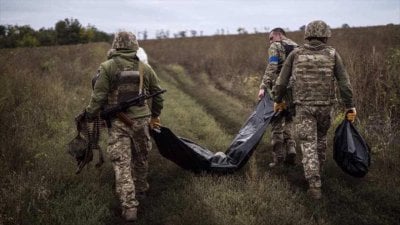 Los militares ucranianos llevan una bolsa que contiene el cuerpo de un soldado ucraniano. (Foto: AP)