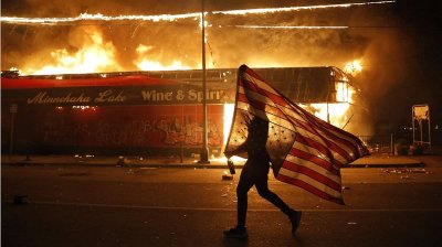 manifestante-porta-una-bandera-estadounidense-reves-junto-edificio-llamas-minneapolis-jueves-m...jpg
