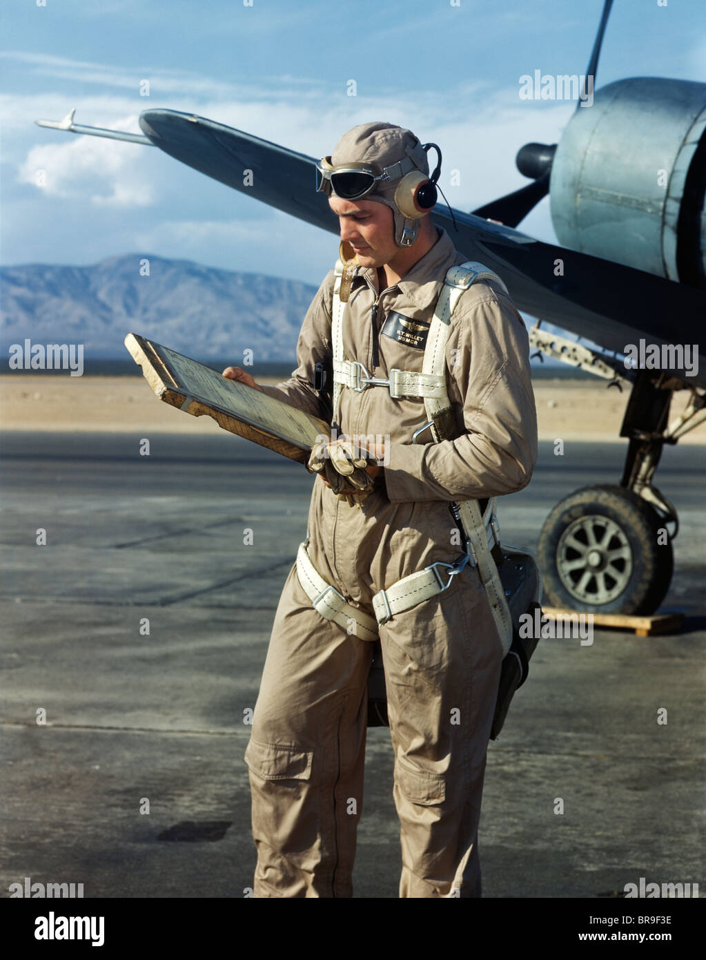 1940s-air-force-pilot-standing-by-plane-going-over-checklist-flight-BR9F3E.jpg